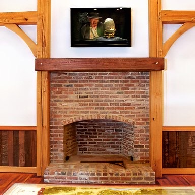 A rustic fireplace using a large original finish heart pine beem from E. T. Moore. - E.T. Moore Custom Home